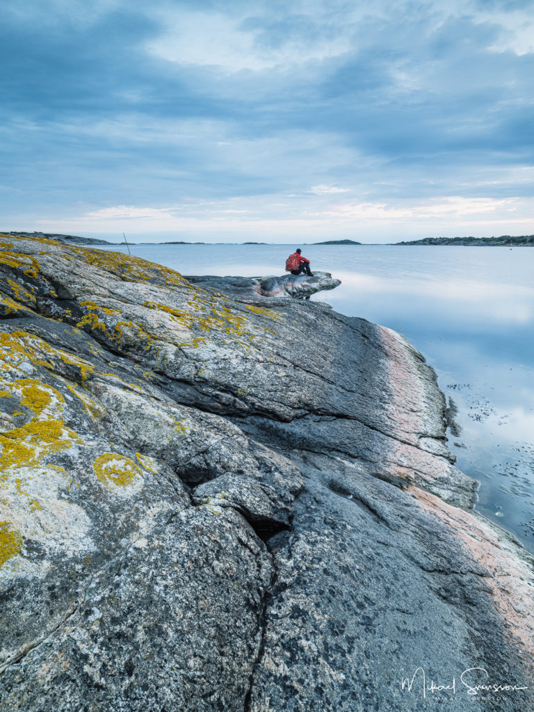 Man sitter på klippa vid Nötö, Hisingen.