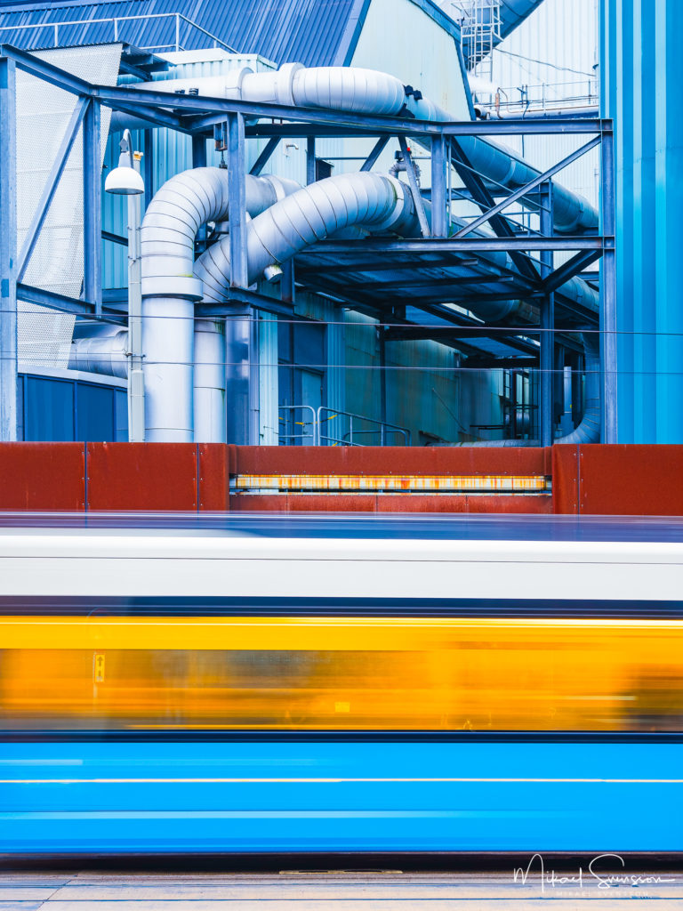 Spårvagn i rörelse framför fjärrvärmeverk, Göteborg.