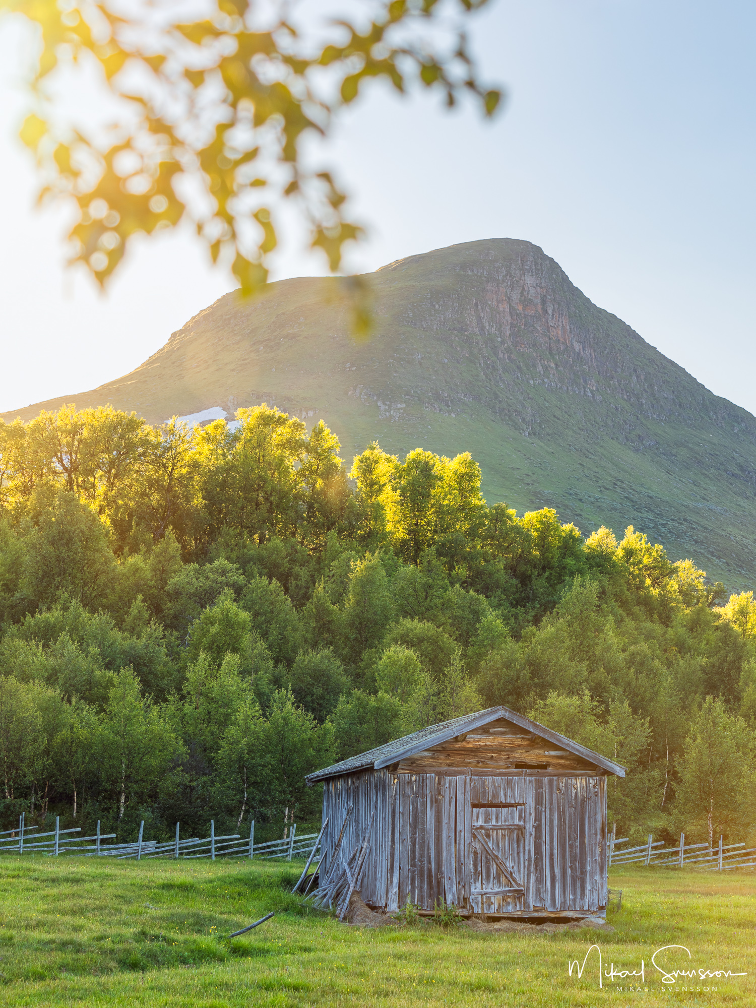 Kvällsljus vid bebyggelse vid Storkläppvallen och foten av Mittåkläppen, Härjedalen.