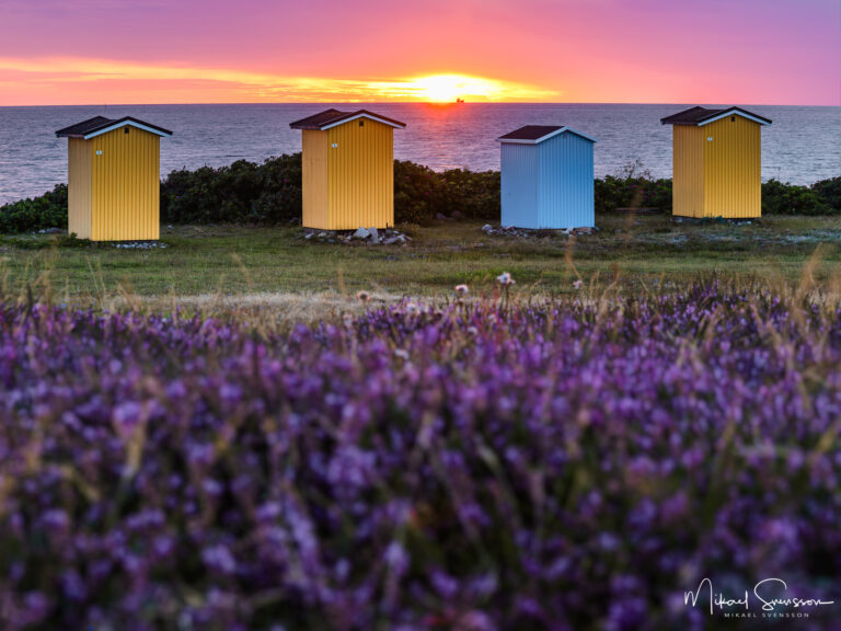 Solnedgång bakom sjöbodar vid Viken havsbad, Höganäs kommun, Skåne.