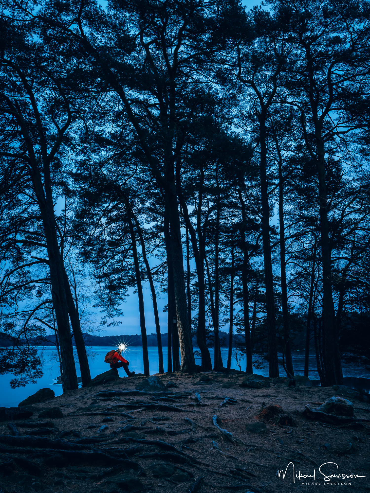 Tidig morgon vid Stora Delsjön, Göteborg. Man sitter med tänd pannlampa.