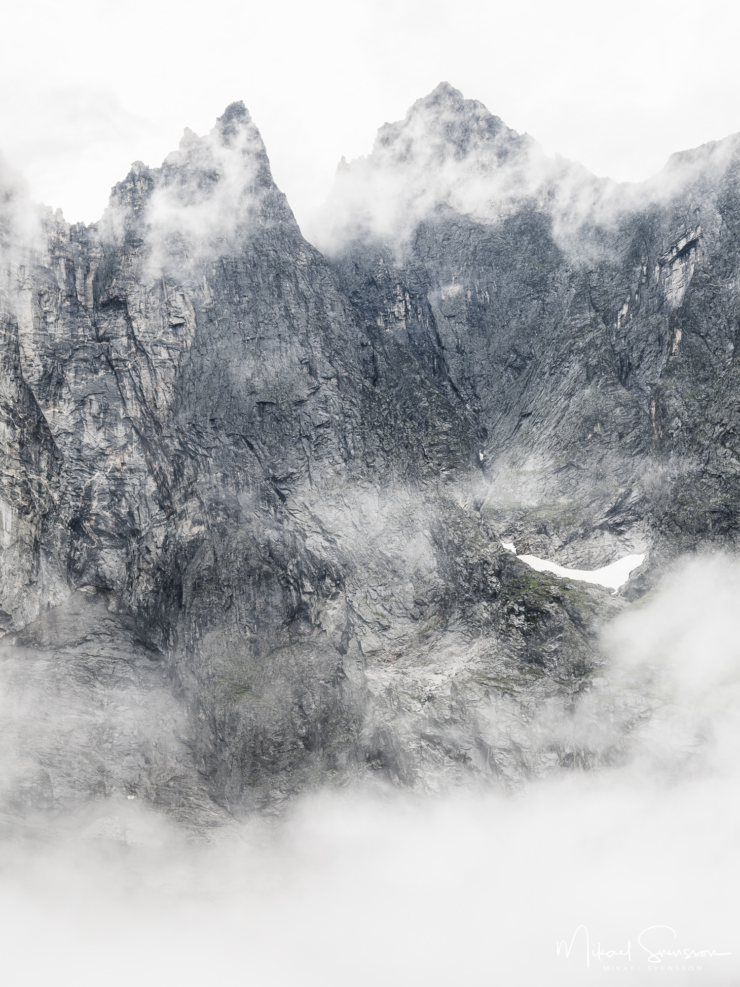 Låga moln vid fjällmassivet Trollveggen, Møre og Romsdal fylke, Norge.