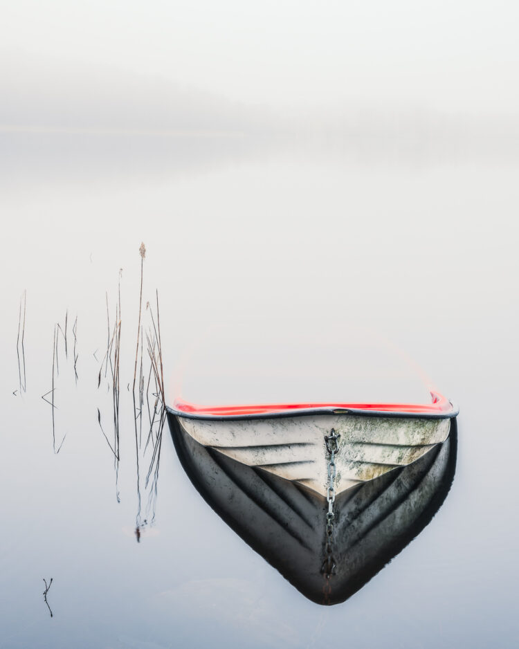 Vattenfylld båt vid sjö med dimma. Tulebo, Mölndal.