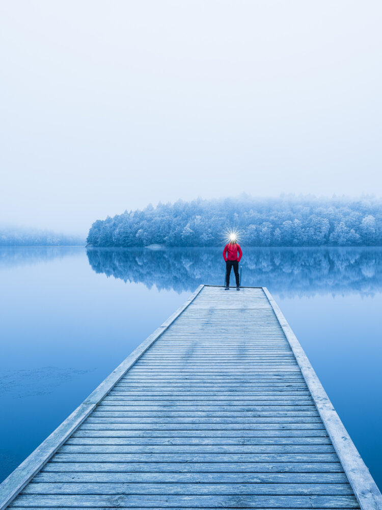 Man står på brygga vid frostig sjö. Kåsjön, Partille.
