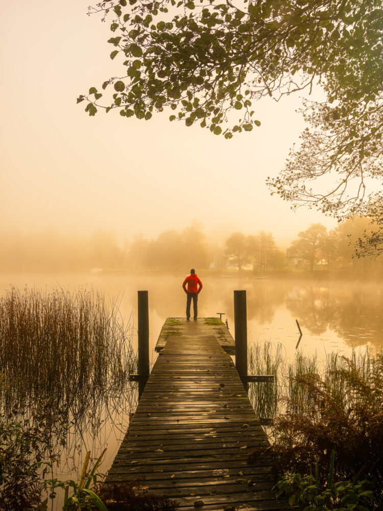 Man står på brygga vid soluppgång