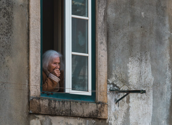 Kvinna vid fönster, Lissabon, Portugal.