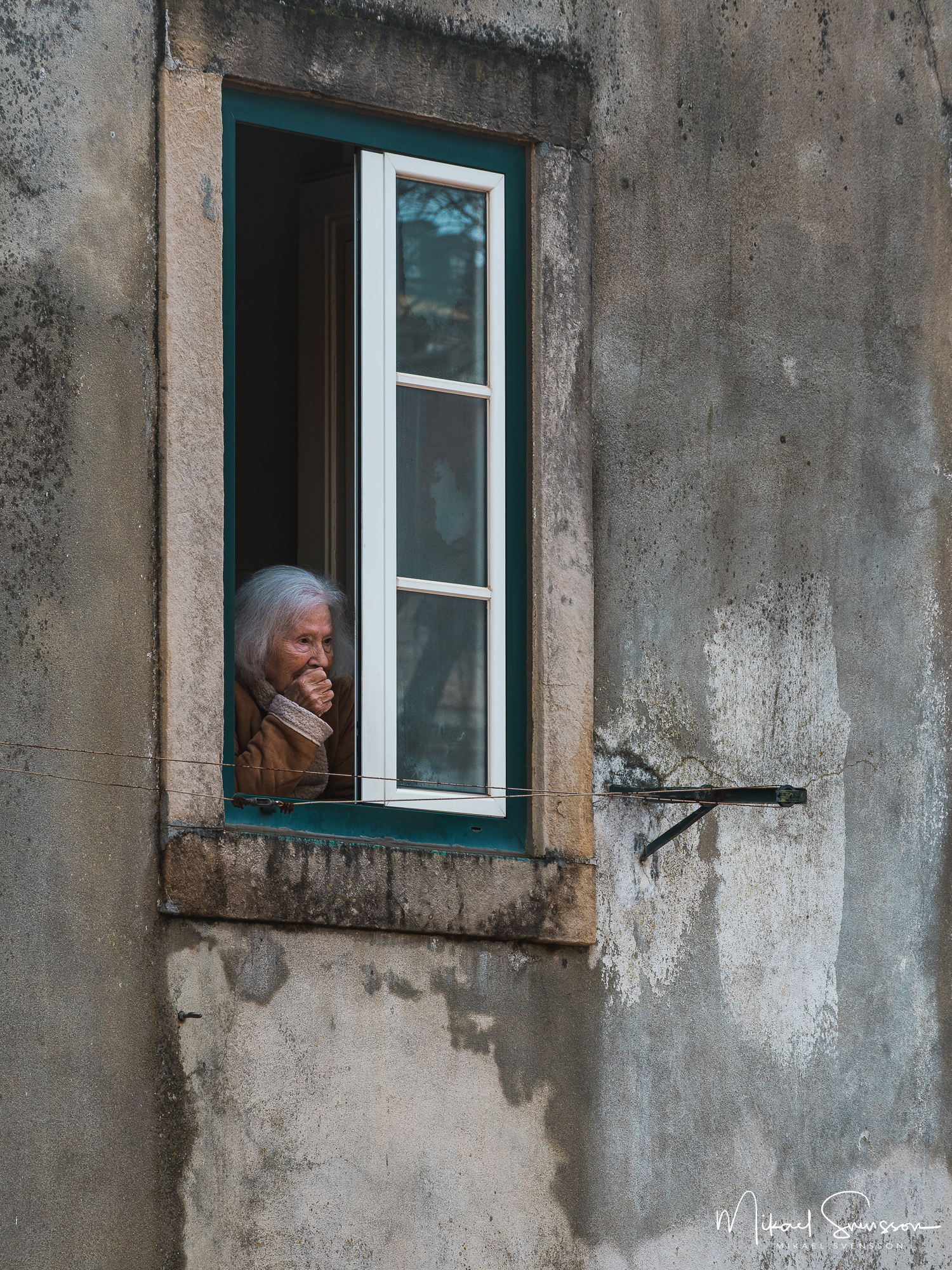 Kvinna vid fönster, Lissabon, Portugal.